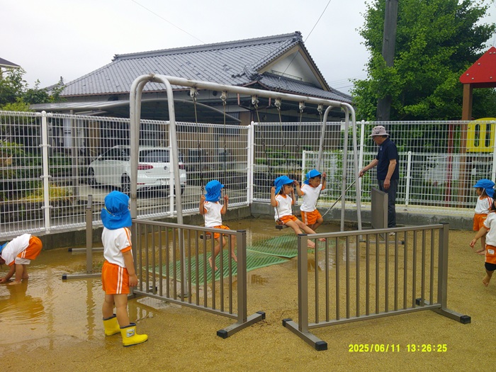 水たまりを小さくしている園長